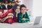 Photo picture of lovely nice cute smiling youngsters want choose more christmas gifts lying floor near fir tree use