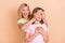 Photo of playful happy mother and daughter hands cover eyes game guess amazed isolated on beige color background