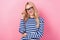 Photo of pleasant gorgeous woman with curly hairdo dressed striped shirt fingers touch glasses smiling  on pink