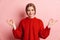 Photo of pleased nice woman in red sweater smiling and holding fingers