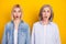 Photo portrait of amazed mother and daughter staring amazed with opened mouth isolated vibrant yellow color background