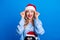 Photo portrait of attractive blonde young woman fix headwear excited dressed penguin sweater x-mas hat isolated on blue