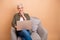 Photo portrait of attractive retired woman armchair netbook look empty space wear trendy khaki clothes  on beige