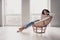 Photo portrait of attractive young woman armchair relax look empty space dressed casual clothes cozy day light home