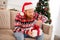 Photo portrait bearded man unpacking xmas present box in headwear curious sitting on couch