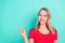 Photo portrait blonde woman pointing finger smiling copyspace isolated vibrant turquoise background