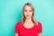 Photo portrait blonde woman serious face wearing dotted red t-shirt isolated vibrant turquoise background