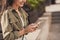 Photo portrait cropped of smiling woman holding phone in two hands browsing internet