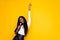 Photo portrait of curious black skinned woman singing song keeping microphone dancing isolated bright yellow color