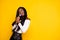 Photo portrait of curious black skinned woman singing song keeping microphone looking copyspace isolated vibrant yellow