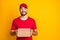 Photo portrait of curious courier holding carton box for delivery looking blank space isolated on vibrant yellow color