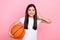 Photo portrait of cute schoolgirl show thumb up hold basketball excited wear trendy white outfit  on pink color