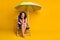 Photo portrait of dreamy girl sitting in blue deckchair under beach umbrella holding head glasses with hand wearing pink