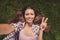 Photo portrait of girl chilling relaxing laying on grass taking selfie showing v-sign gesture