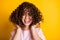 Photo portrait of girl with curly hairstyle wearing t-shirt laughing touching hair isolated on bright yellow color