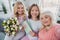 Photo portrait of granny daughter granddaughter smiling taking selfie with tulips postcard at home