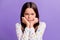 Photo portrait of grumpy child holding head with two hands isolated on vivid violet colored background