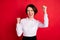 Photo portrait of happy business woman lucky cheerful gesturing like winner isolated bright red color background