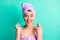 Photo portrait happy surprised woman turban on head moisturizing in bath gesturing like winner isolated vibrant teal