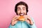 Photo portrait of hungry man taking massive bite of cheeseburger isolated on pastel pink colored background