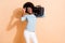 Photo portrait of impressed black skinned girl holding boombox on shoulder raising glasses up isolated on pastel beige