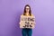 Photo portrait of jobless girl keeping carton placard searching for work isolated on vivid purple color background