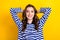 Photo portrait of lovely young lady arms behind head have rest sleepy wear trendy striped outfit isolated on yellow