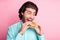 Photo portrait of man taking big bite of cheeseburger isolated on pastel pink colored background