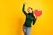 Photo portrait overjoyed dreamy female student keeping heart valentines day gesturing like winner isolated bright yellow