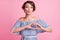 Photo portrait of pouting girl making heart shape at chest with hands isolated on pastel pink colored background