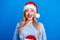 Photo portrait of pretty blonde young girl excited impressed toothy smile wear sweater x-mas hat isolated on blue color