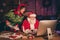 Photo portrait of santa claus and elf looking at computer screen holding bunch of letters