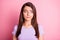 Photo portrait of sceptical woman looking to side  on pastel pink colored background