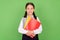 Photo portrait schoolgirl keeping book stack at school isolated pastel green color background