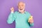 Photo portrait of senior man keeping mobile phone gesturing like winner cheerfully isolated on pastel violet color