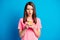 Photo portrait of shocked astonished female student browsing internet cellphone isolated on vibrant blue color