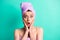 Photo portrait shocked woman turban on head doing hygiene procedures touching cheekbones isolated vivid teal color