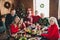 Photo portrait of smiling family sitting at table celebrating christmas spending together family time