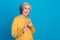Photo portrait of stunning grandma fingers point you cool energetic promoter wear trendy yellow outfit isolated on blue