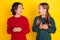 Photo portrait two children amazed using cellphones looking each at other isolated vivid yellow color background