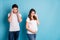 Photo portrait of two people couple pregnant wife crying wiping tears irritated husband behind isolated vivid blue color