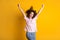 Photo portrait of victorious woman raising two hands isolated on vivid yellow colored background