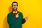 Photo portrait of young attractive male specs look fingers point empty space wear trendy green outfit isolated on yellow