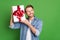 Photo portrait of young guy smiling in denim shirt trying to guess what in present curious isolated on vivid green color