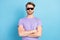 Photo portrait of young man in black sunglass serious crossed hands isolated on pastel blue color background
