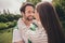 Photo portriat young couple smiling hugging each other walking in green city park