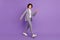 Photo of positive carefree pupil guy walk school break wear grey suit isolated violet color background