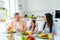 Photo of positive charming married couple small daughter talking enjoying tasty breakfast indoors home kitchen