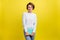 Photo of positive charming pretty geek lady hold textbook wear eyewear blue sweater isolated yellow color background