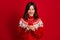 Photo of positive cheerful optimistic girl straight hairstyle wear red sweater typing message in phone isolated on red